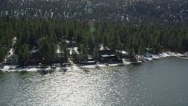 5K aerial stock footage flyby homes on the shore of Big Bear Lake with light winter snow, California Aerial Stock Footage | AX0010_024