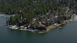 5K aerial stock footage orbit large waterfront homes on the shore of Big Bear Lake with light winter snow, California Aerial Stock Footage | AX0010_025