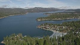 5K aerial stock footage fly over a mountain slope to reveal Big Bear Lake in winter, California Aerial Stock Footage | AX0010_029