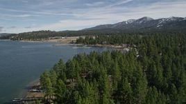5K aerial stock footage tilt to reveal and approach shore of Big Bear Lake with light winter snow, California Aerial Stock Footage | AX0010_036