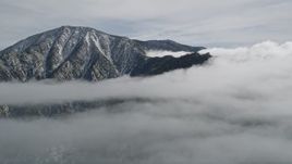 5K aerial stock footage orbit summit of a peak with light snow in the San Jacinto Mountains, California Aerial Stock Footage | AX0010_090
