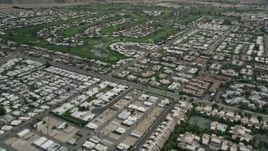 5K aerial stock footage fly over West Palm Springs neighborhoods and tilt to reveal and orbit golf course, California Aerial Stock Footage | AX0010_131E