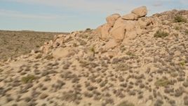 5K aerial stock footage pan past Joshua Trees and over rock formations, Joshua Tree National Park, California Aerial Stock Footage | AX0011_035