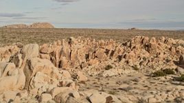 5K aerial stock footage fly over rock formations revealing Joshua Trees, Joshua Tree National Park, California Aerial Stock Footage | AX0011_036