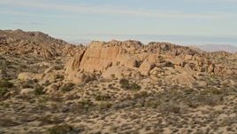 5K aerial stock footage fly by Joshua Trees and rock formations, Joshua Tree National Park, California Aerial Stock Footage | AX0011_038