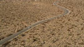 5K aerial stock footage of tracking a car on a desert road, Joshua Tree National Park, California Aerial Stock Footage | AX0011_043E