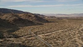 5K aerial stock footage of flying by a winding desert road, Joshua Tree National Park, California Aerial Stock Footage | AX0011_045