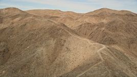 5K aerial stock footage of following a desert mountain trail, Mojave Desert, California Aerial Stock Footage | AX0011_052