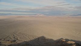 5K aerial stock footage fly low over a mountain revealing desert plain, Mojave Desert, California Aerial Stock Footage | AX0011_064