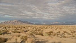 5K aerial stock footage fly low over desert toward mountains, Mojave Desert, California Aerial Stock Footage | AX0012_002