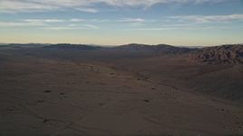 5K aerial stock footage of desert plain and mountains at sunset, Mojave Desert, California Aerial Stock Footage | AX0012_056