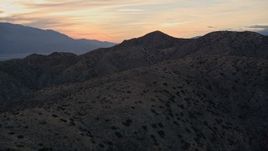 5K aerial stock footage fly low over desert mountains, Mojave Desert, California, sunset Aerial Stock Footage | AX0012_066