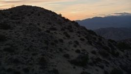 5K aerial stock footage fly over desert mountain revealing a valley, Mojave Desert, California, sunset Aerial Stock Footage | AX0012_068