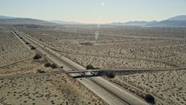 5K aerial stock footage of flying over an interstate passing through desert and a windmill farm, Palm Springs, California Aerial Stock Footage | AX0013_024