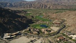 5K aerial stock footage fly over upscale homes toward golf course among mountains, Indian Wells, California Aerial Stock Footage | AX0013_082