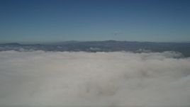 5K aerial stock footage flyby and pan across a thick layer of clouds to reveal the edge of the layer in California Aerial Stock Footage | AX0016_011