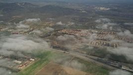 5K aerial stock footage flyby neighborhoods, and pan to military base below cloudy skies, Oceanside, Camp Pendleton, California Aerial Stock Footage | AX0016_022