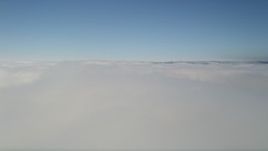 5K aerial stock footage fly over a cover of clouds and tilt up to blue sky, California Aerial Stock Footage | AX0016_041