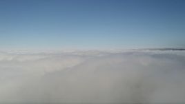 5K aerial stock footage pan across cloud cover and a break in the clouds, with blue skies above, California Aerial Stock Footage | AX0016_046