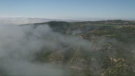 5K aerial stock footage fly over fog over green hills near hilltop homes in Newport Beach, California Aerial Stock Footage | AX0016_067