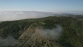 5K aerial stock footage fly over hills and fog toward mountains ridge in Newport Beach, California Aerial Stock Footage | AX0016_068E