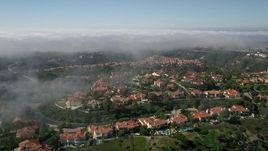 5K aerial stock footage approach and fly over hilltop mansions near a fog bank, Newport Beach, California Aerial Stock Footage | AX0016_070E