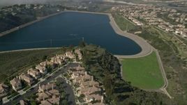 5K aerial stock footage track a group of homes in a residential neighborhood by the San Joaquin Reservoir, Newport Beach, California Aerial Stock Footage | AX0016_074