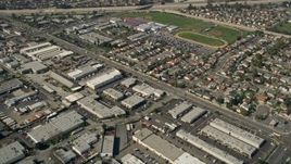 5K aerial stock footage tilt from warehouses to reveal Los Alamitos High School, residential neighborhoods, and Coyote Creek, Los Alamitos, California Aerial Stock Footage | AX0016_101