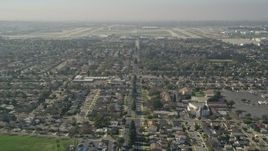5K aerial stock footage tilt up East Warlow Road to reveal and approach neighborhoods and Long Beach Airport, California Aerial Stock Footage | AX0016_106