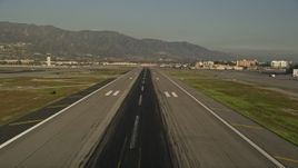 5K aerial stock footage of lifting off from Bob Hope International Airport revealing a passenger jet, Burbank, California Aerial Stock Footage | AX0017_113