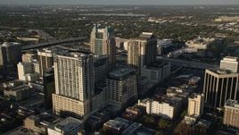 5K aerial stock footage fly over Lake Eola to approach office buildings and arena in Downtown Orlando at sunrise, Florida Aerial Stock Footage | AX0018_004E