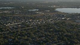 5K aerial stock footage of suburban Orlando neighborhood beside Lake Baldwin at sunrise, Florida Aerial Stock Footage | AX0018_024