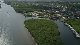 5K aerial stock footage fly over Indian River and pan to approach waterfront homes in Hobe Sound, Florida Aerial Stock Footage | AX0019_013E