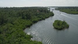 5K aerial stock footage approach and fly over mangroves lining the Indian River near bridge in Hobe Sound, Florida Aerial Stock Footage | AX0019_015E