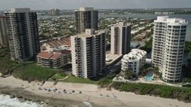 5K aerial stock footage of beachfront condominium complexes by the ocean in Riviera Beach, Florida Aerial Stock Footage | AX0019_047