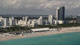 5K aerial stock footage of crowd of sunbathers near beachfront hotels in Miami Beach, Florida Aerial Stock Footage | AX0020_048