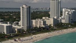 5K aerial stock footage of beachfront hotels and sunbathers by the ocean in Miami Beach, Florida Aerial Stock Footage | AX0020_053