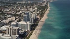 Flyby Beachfront Hotels and Tilt to Sunbathers in Miami Beach  Aerial Stock Footage | AX0020_063