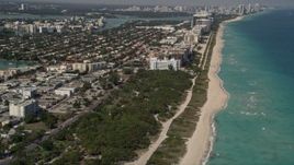 5K aerial stock footage tilt from beachfront homes and park to reveal coastal hotels in Miami Beach and town of Surfside, Florida Aerial Stock Footage | AX0020_065