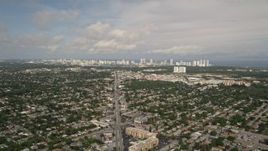 5K aerial stock footage of suburban area with distant coastal skyscrapers in Sunny Isles Beach, Florida Aerial Stock Footage | AX0021_002