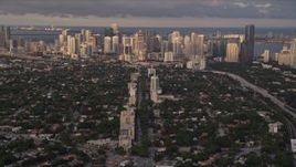 5K aerial stock footage tilt from Coral Gables suburbs to reveal Downtown Miami at sunset in Florida Aerial Stock Footage | AX0022_023