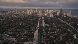 5K aerial stock footage of following SW 3rd Avenue through suburbs to approach Downtown Miami at sunset, Florida Aerial Stock Footage | AX0022_024