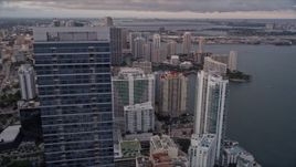 5K aerial stock footage orbit top of Four Seasons Hotel to reveal waterfront skyscrapers in Downtown Miami at sunset, Florida Aerial Stock Footage | AX0022_043
