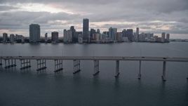 5K aerial stock footage tilt to reveal and fly over Rickenbacker Causeway to approach Downtown Miami at sunset, Florida Aerial Stock Footage | AX0022_076E