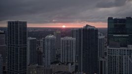 5K aerial stock footage of setting sun behind tall skyscrapers in Downtown Miami, Florida Aerial Stock Footage | AX0022_085E