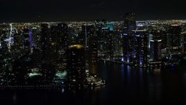 5K aerial stock footage of flying by high-rises on the shore of Brickell Key at night and reveal river in Downtown Miami, Florida Aerial Stock Footage | AX0023_057E