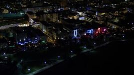 5K aerial stock footage of hotels and cafes with bright lights at night in South Beach, Florida Aerial Stock Footage | AX0023_071E