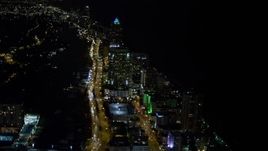 5K aerial stock footage fly over busy streets through Miami Beach at night, tilt to approach a resort hotel, Florida Aerial Stock Footage | AX0023_083E