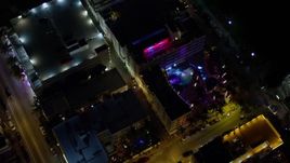 5K aerial stock footage bird's eye view of a South Beach hotel with bright lights at nighttime, Florida Aerial Stock Footage | AX0023_116