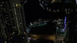 5K aerial stock footage flyby yacht on the river and Downtown Miami skyscrapers at night, Florida Aerial Stock Footage | AX0023_170E